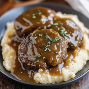 Tender Slow Cooker Salisbury Steaks served with gravy and mashed potatoes.