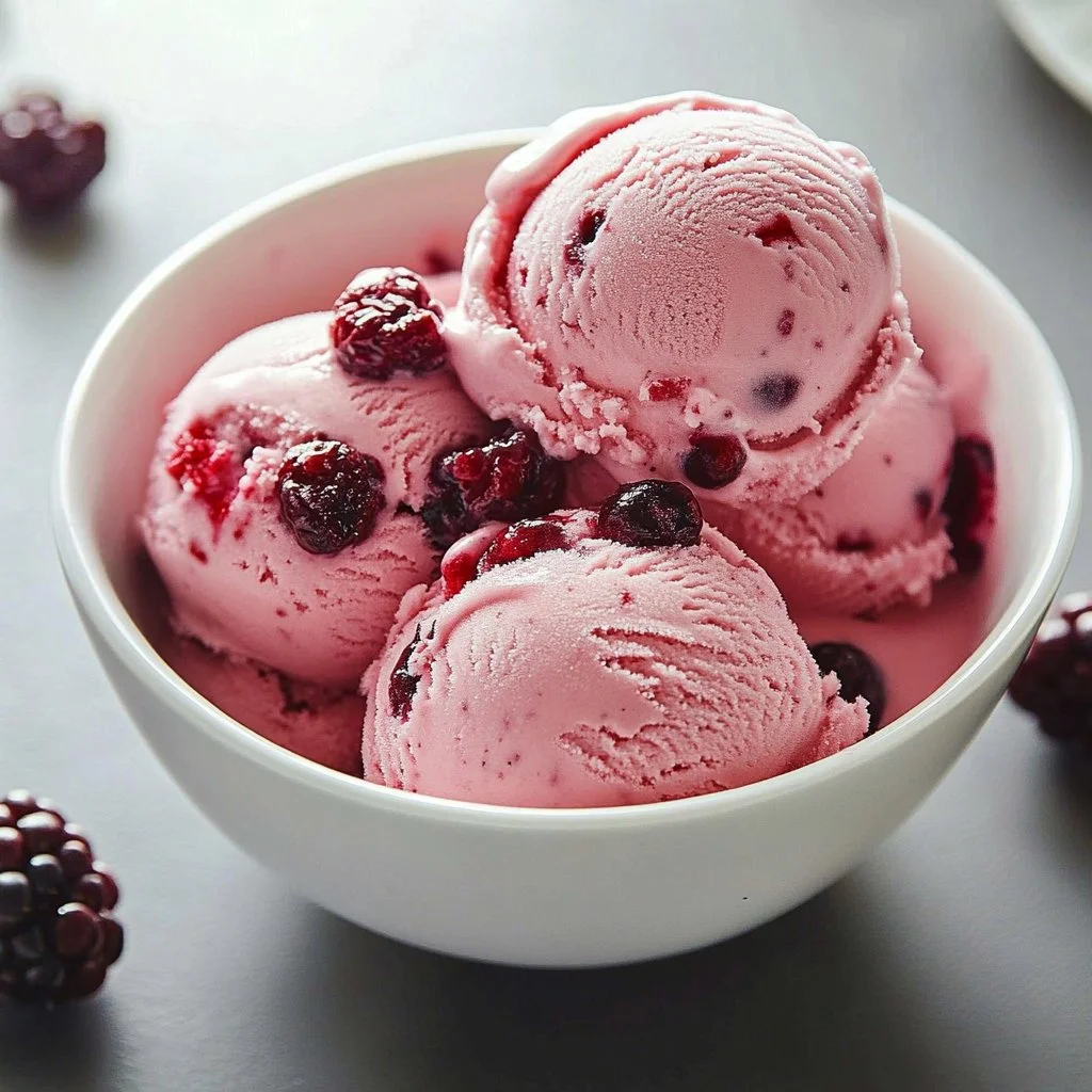 Delicious cranberry ice cream served in a bowl with fresh cranberries on top.